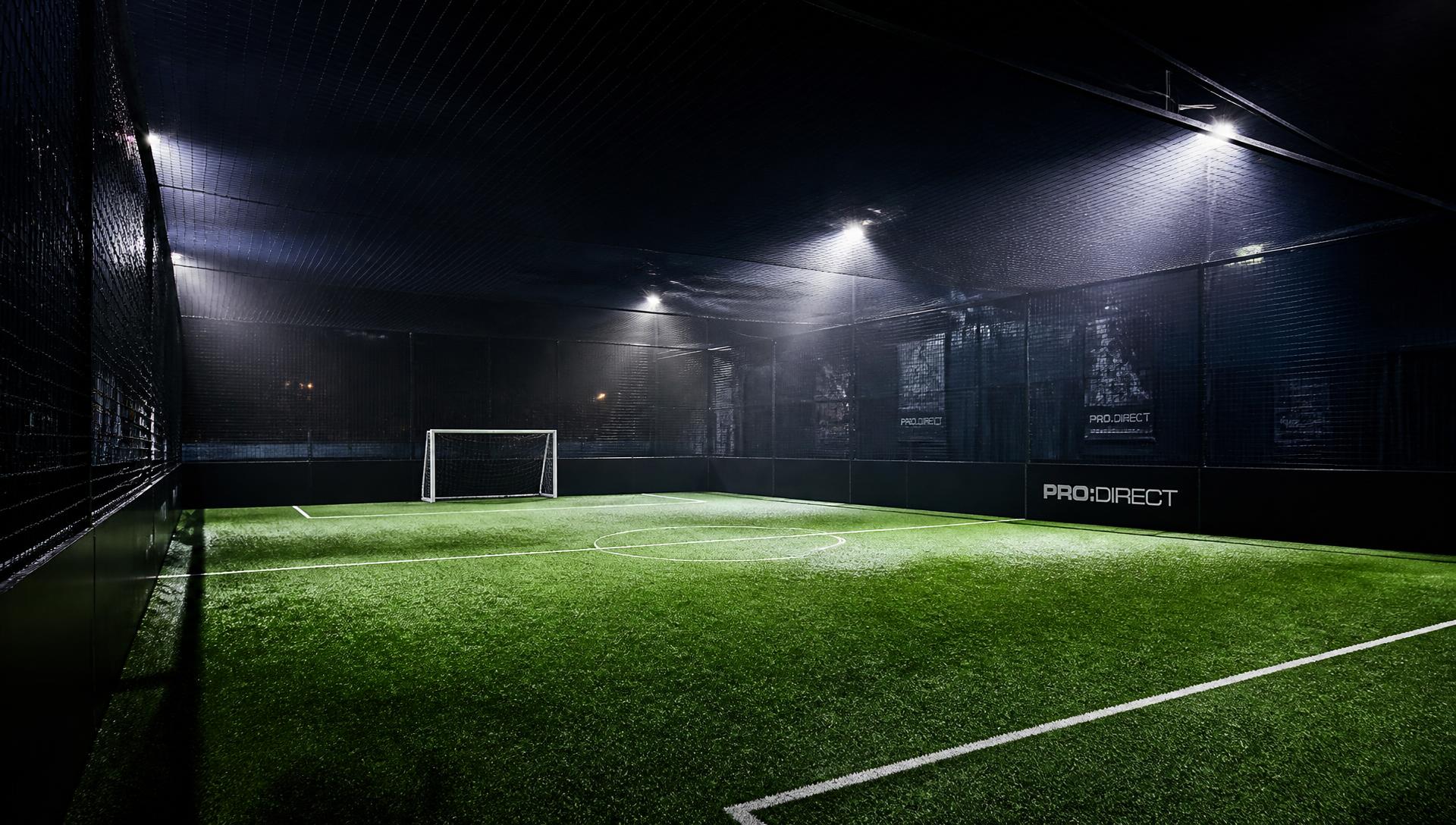 Innendørs cageball-bane med kunstgress og flomlys